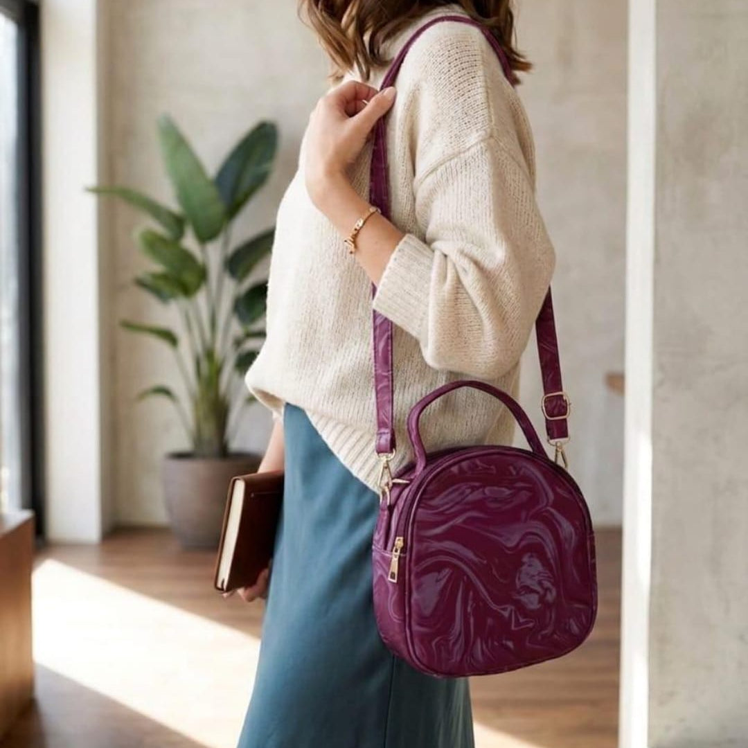Side view of a person wearing the Range Studio swirl canten silhouette in deep magenta purple featuring a glossy marble pattern and an adjustable shoulder strap.