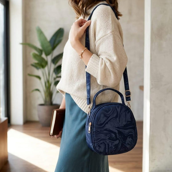 Sleek midnight navy blue minimalist swirl round accessory highlighting clean lines, fine stitching, and premium gold-toned zipper pulls.