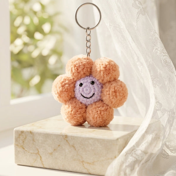  The plush hand-crafted flower charm in soft pastel pink highlighting a cozy cloud-soft texture and premium retail styling.