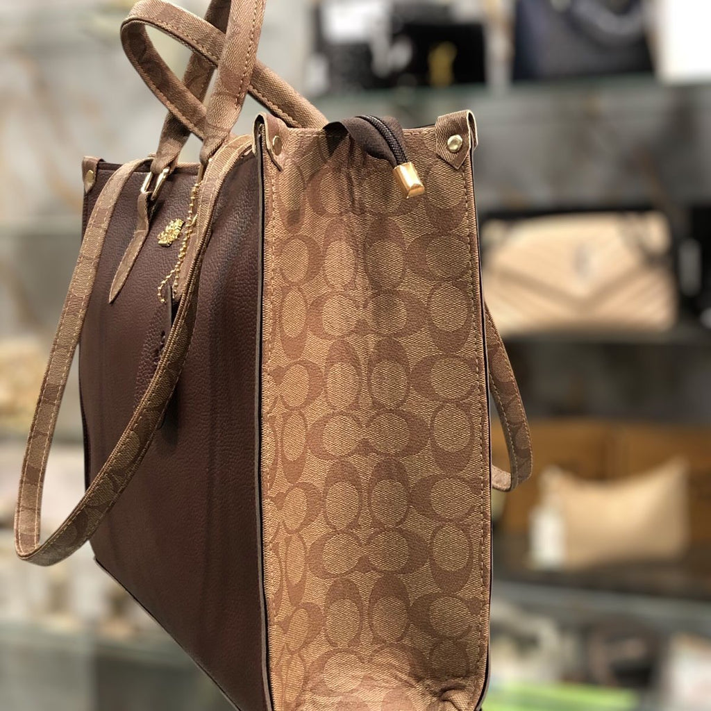 Close-up on the expanding patterned side panels of the espresso brown Range Studio Luxe Carryall.