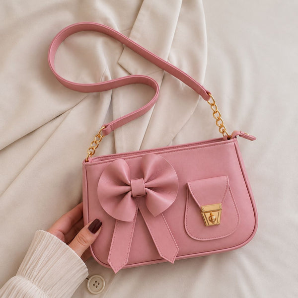 The premium hand-crafted soft pink variation of the structured shoulder silhouette highlighting delicate chain links and coquette design accents.
