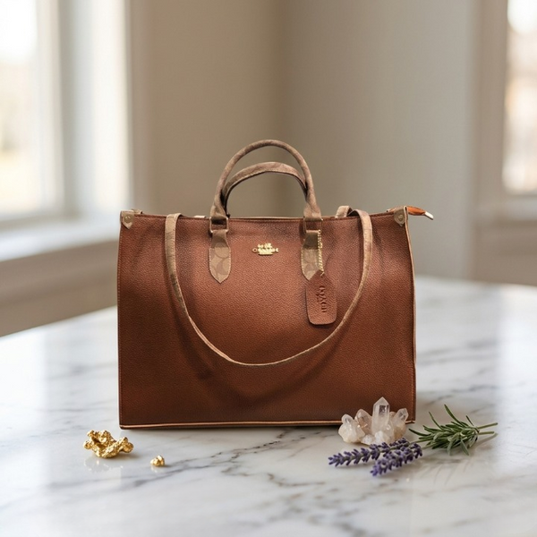 The Tan Copper variation of the Range Studio Accordion Carryall arranged beautifully on a minimalist marble background.