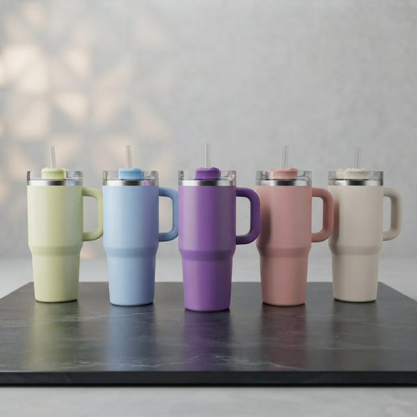 Front display row of five colorful matte Range Studio travel tumblers with handles and straws arranged on a shop display shelf.