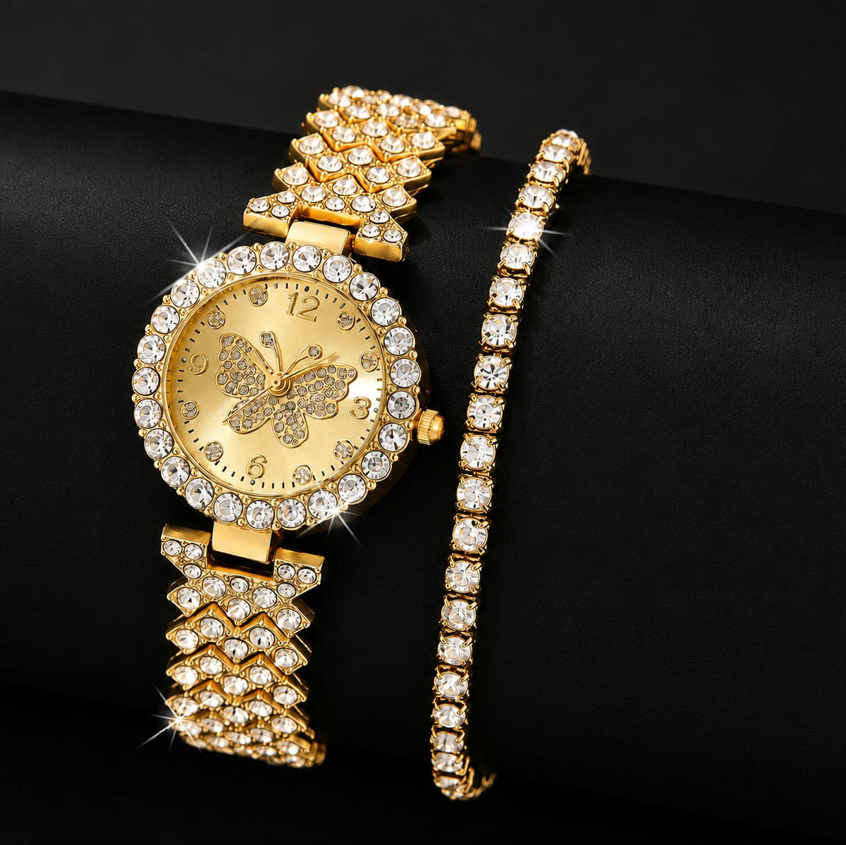 Front angle view of the Imperial Gold variant Range Studio butterfly watch and matching single-strand crystal tennis bracelet on a black studio display. Main image