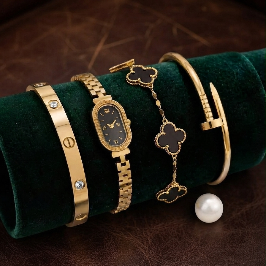 • range-studio-imperial-serenade-watch-set-emerald-cushion
• Alt-Text: Side angle view of the Range Studio gold oval watch and three matching luxury bangles displayed on a deep green velvet roll Main image