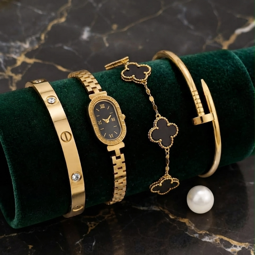 Aesthetic presentation of the Range Studio gold oval timepiece and black clover bracelet stack styled on a premium dark veined marble surface