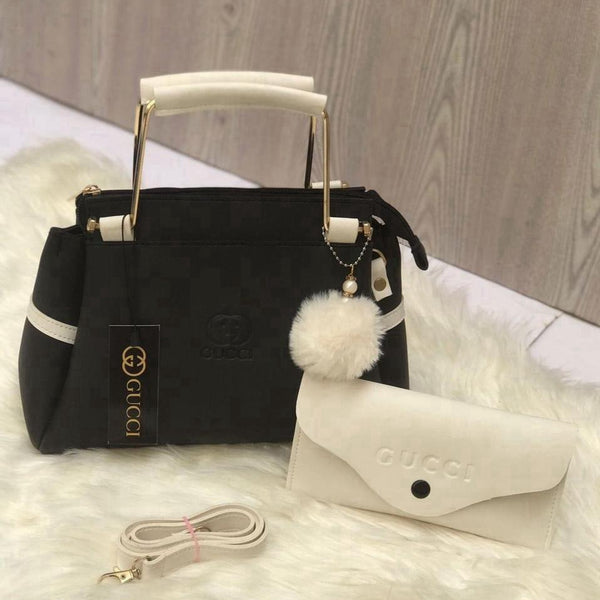 Front showcase of the Range Studio premium black and white contrast top-handle fashion accessory with a structured silhouette and matching mini pouch.