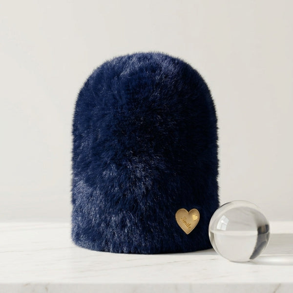 Aesthetic studio display of the Midnight Sapphire deep navy blue plush rabbit wool beanie by Range Studio highlighting the polished gold heart charm.