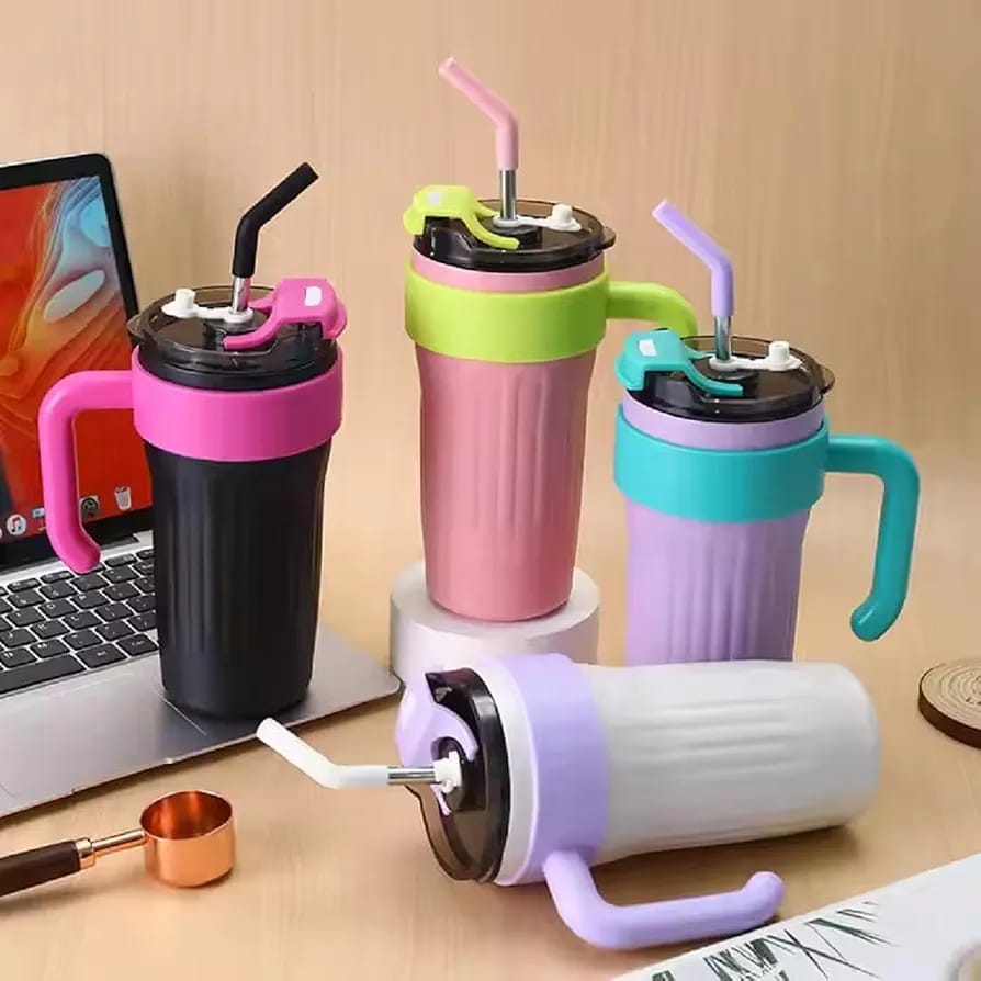 Aesthetic lifestyle arrangement of the four color-blocked Range Studio Ribbed Travel Tumblers styled next to a laptop on a wooden studio desk.
